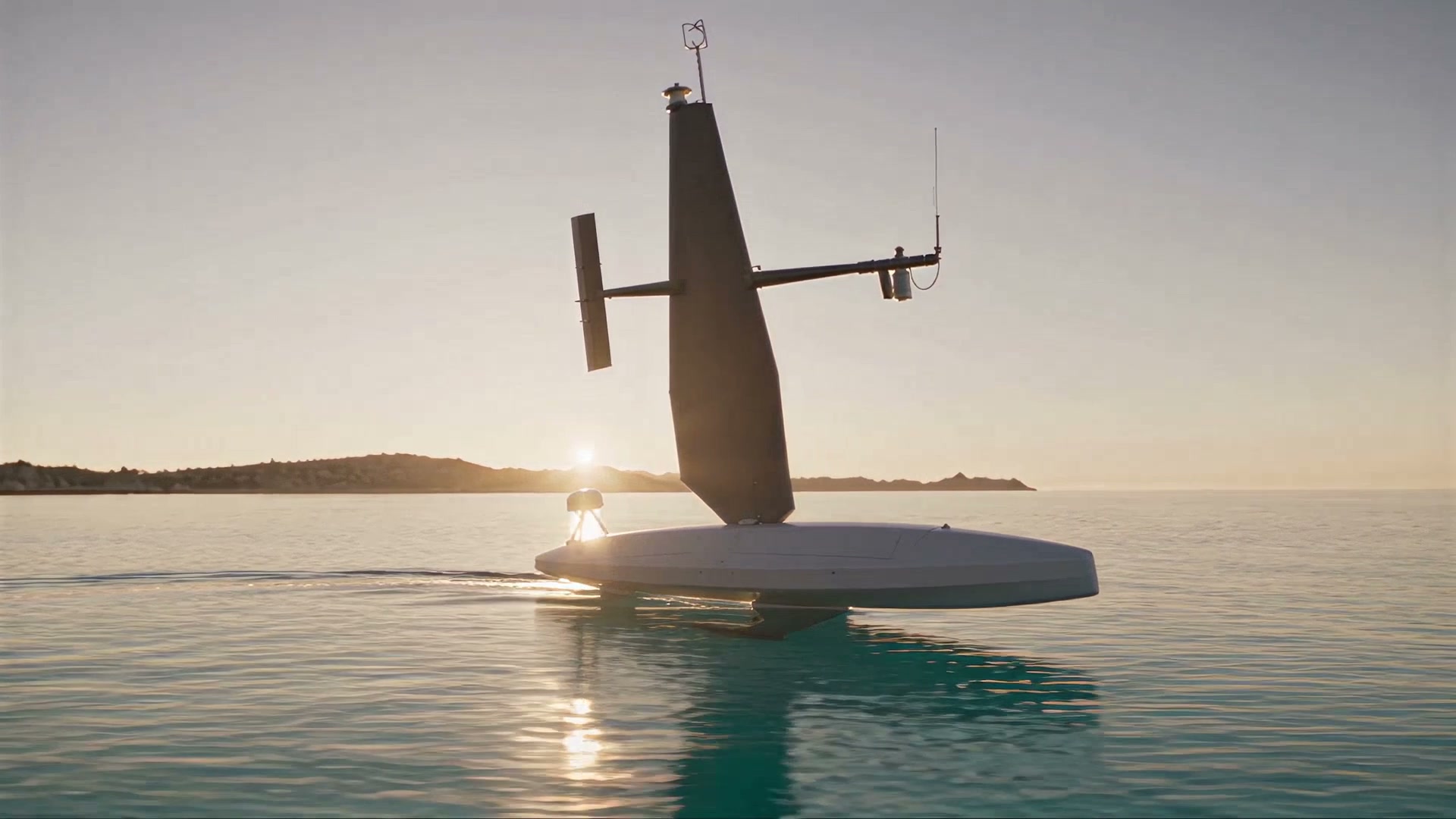 The rigid wing sail against the low sun, the sensor mast on deck